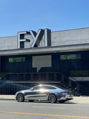 Chrome Mercedes in front of a modern tech building